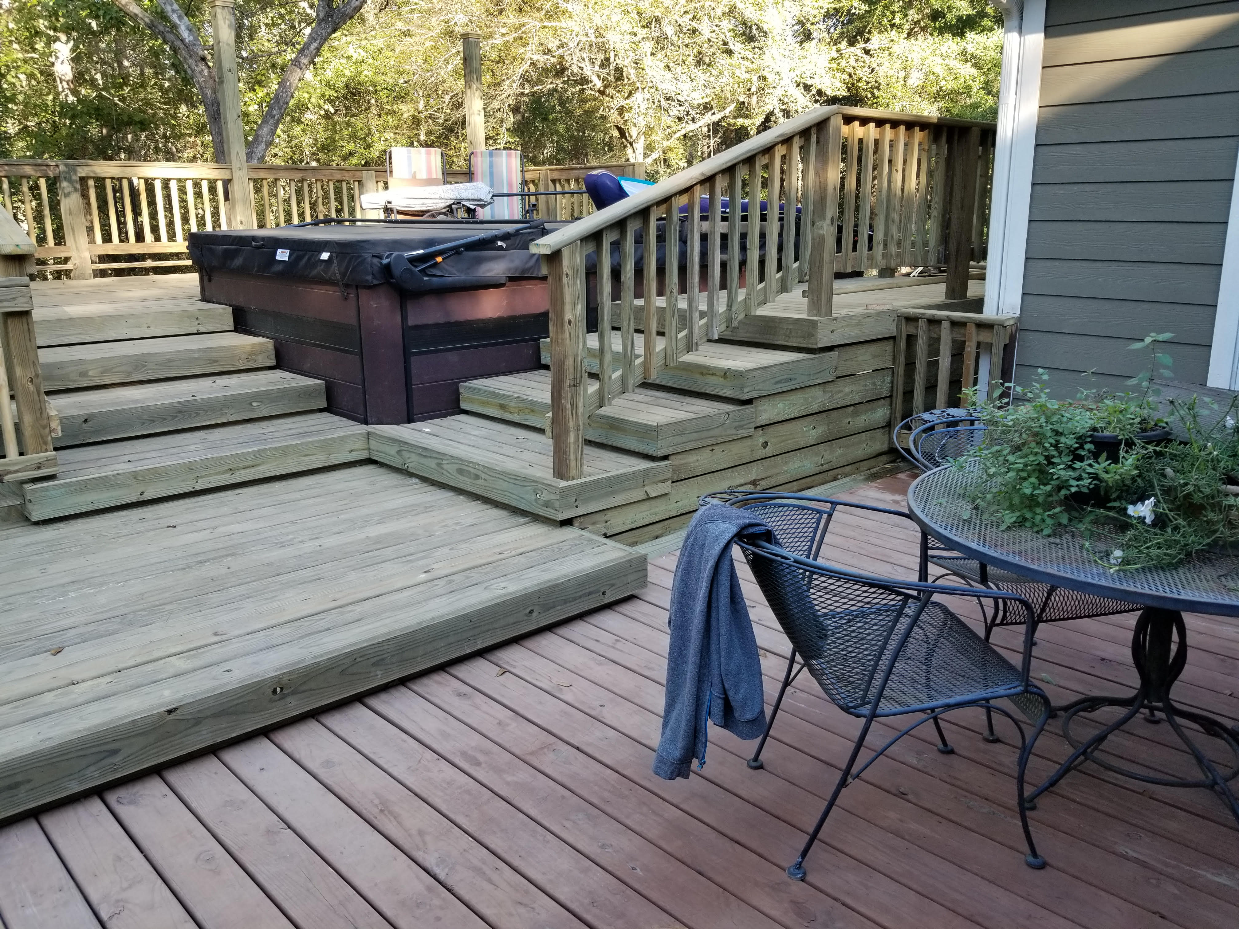Multi-tier wood deck with steps and a built-in hot tub built by Cavalier Custom Decks