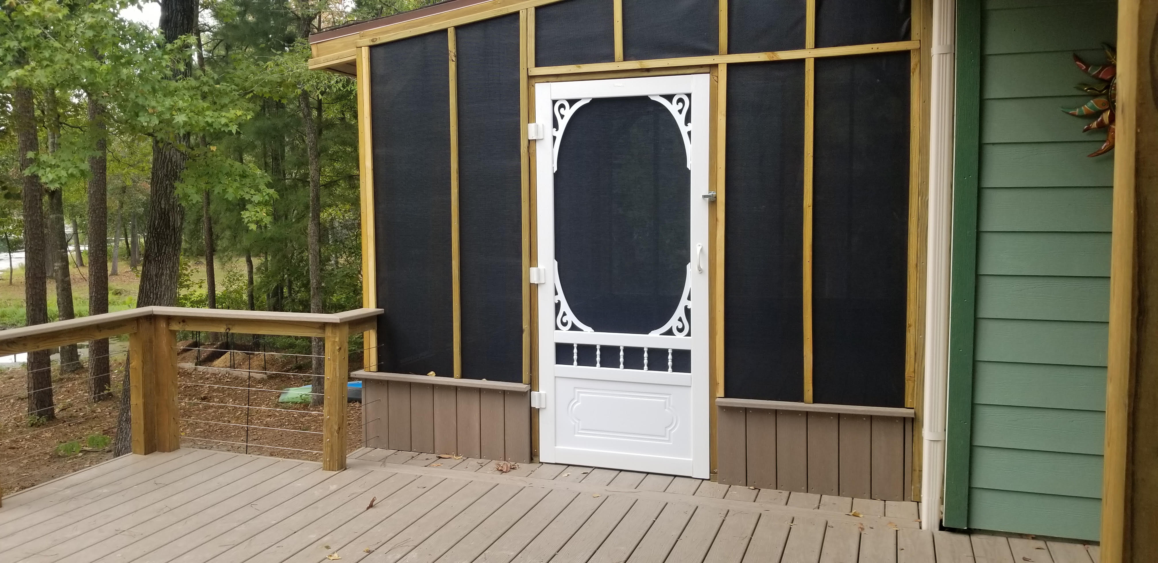 Screened porch addition with a custom ornate screen door built by Cavalier Custom Decks